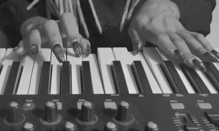 A black and white picture of a woman playing piano, closeup.